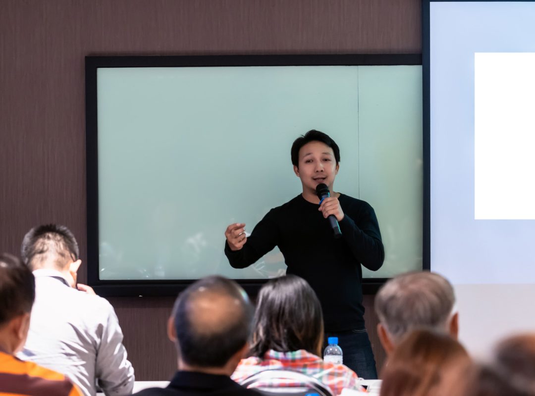 Asian Speaker or lecture with casual suit on the stage in front