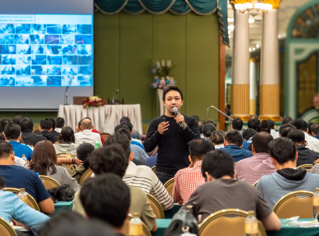 Asian Speaker with casual suit standing and giving the knowledge
