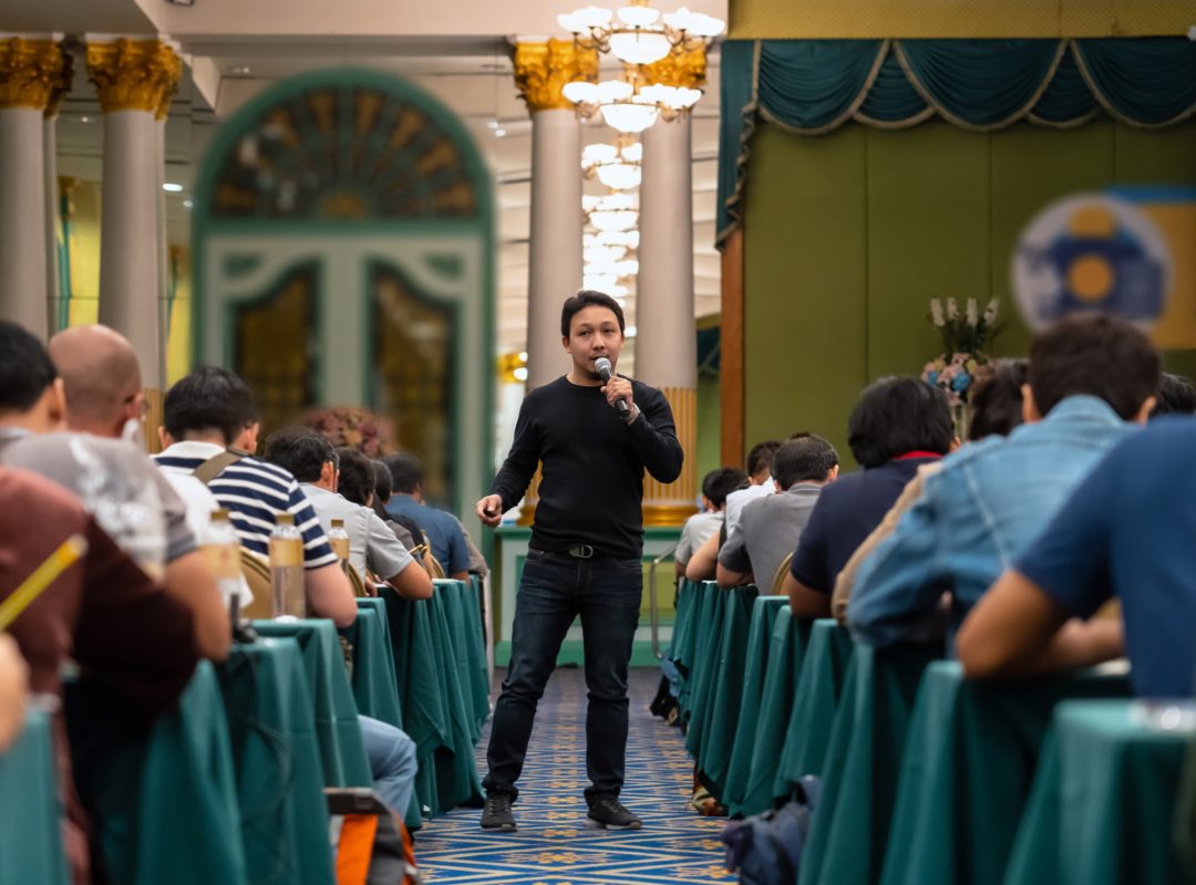 Asian Speaker with casual suit standing and giving the knowledge