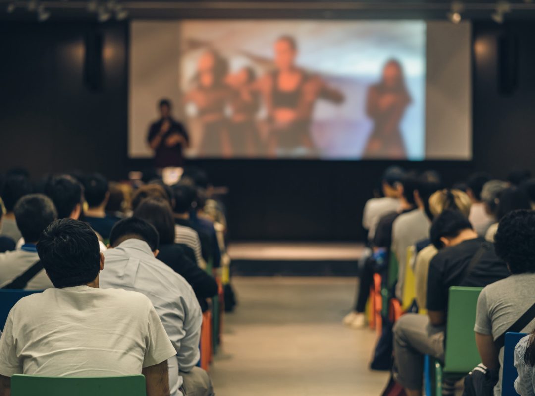 Rear view of Asian audience joining and listening speaker talkin